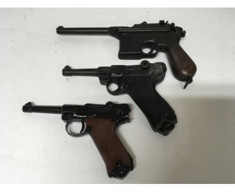 A group of three replica German pistols including a P.08 Pistol, a German made DBGM reduced scale P.08 and a BKA 221 Mauser r