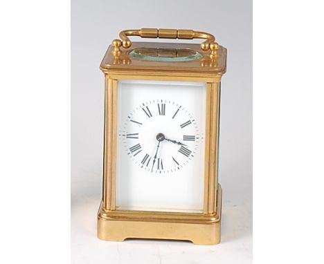 An early 20th century French lacquered brass cased carriage clock, having visible platform escapement over white enamel dial,