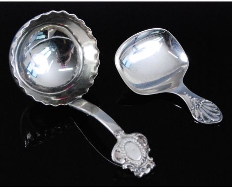 An early 20th century silver caddy spoon, having a deep bowl with wavy rim, the terminal with C-scroll decoration and vacant 