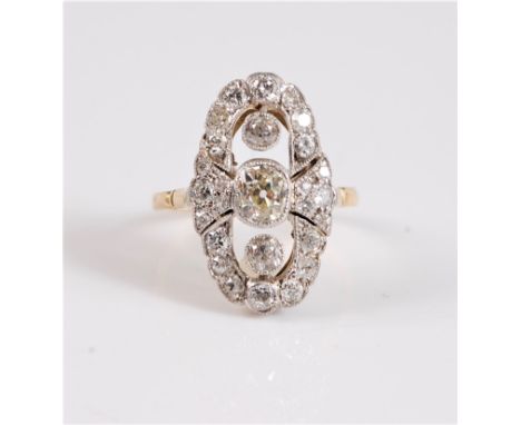 An early 20th century diamond ring, the central old mine cut diamond set above and below with an old brilliant cut diamond, a
