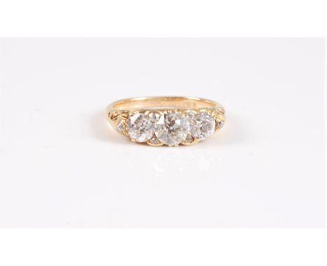 An 18ct three stone diamond ring, the three slightly graduated old round brilliant cut diamonds, with diamond highlights, tot