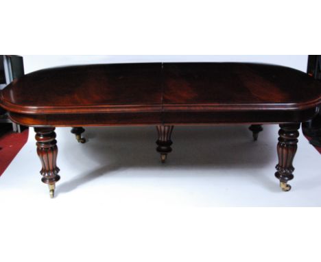 A Victorian style mahogany extending dining table, of good size, the top having pull-out action, moulded edge and four extra 
