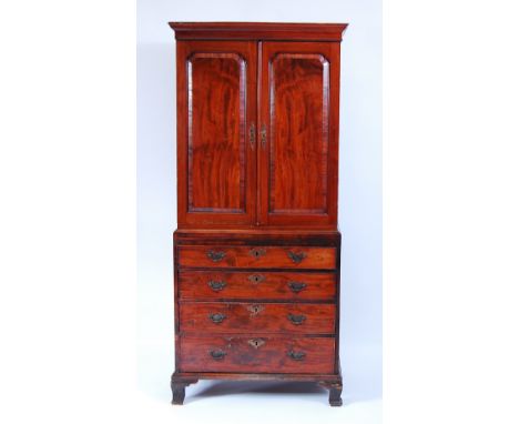 A George III mahogany cabinet on stand, the upper section having twin fielded panelled doors opening to reveal well-fitted in
