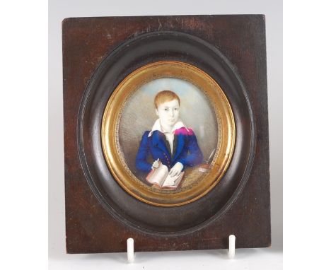 Early 19th century English school - half-length portrait of a young scholar at his desk, wearing a blue tunic, miniature wate