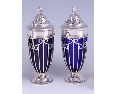 A pair of Edwardian silver sugar casters, each having pierced body with blue glass liner, maker Haseler Brothers, London 1910