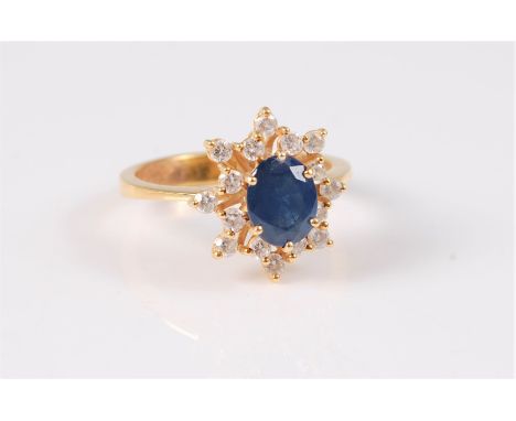 An 18ct sapphire and diamond cluster ring, the oval sapphire, claw mounted and surrounded by small round diamonds, total esti