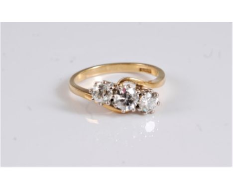 An 18ct three stone crossover diamond ring, the three old cut diamonds, estimated approx. 1.22cts, all claw mounted in white 