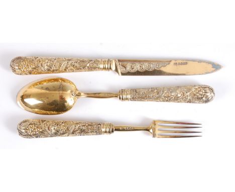 A George IV silver gilt dessert knife, fork and spoon, the loaded handles each worked as fruiting vines, the knife blade with