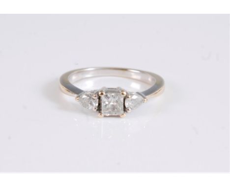 An 18ct three stone diamond ring, the central princess cut cut diamond set to either side with a pear shaped diamond, total w