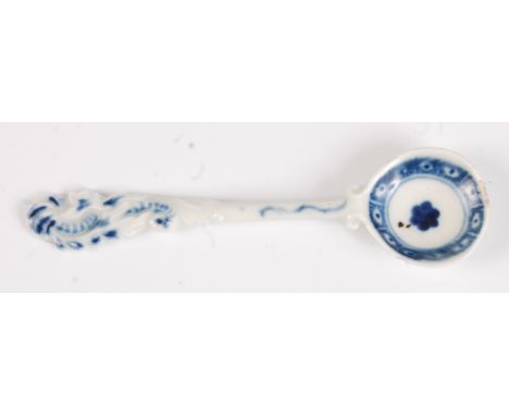 A rare Worcester porcelain salt spoon, circa 1765, the feather scroll terminal with an underglaze blue cell diaper border, 10