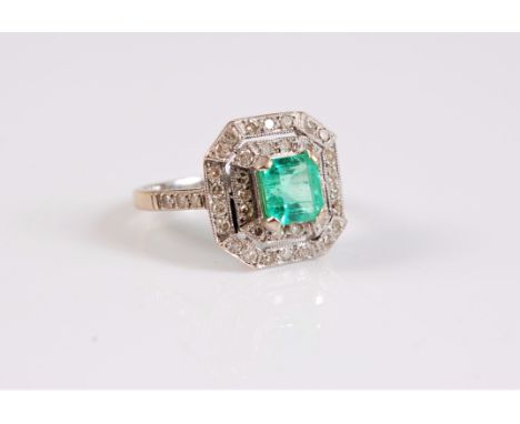 An 18ct Art Deco style emerald and diamond ring, the central square emerald cut emerald, surrounded by two rows of round bril