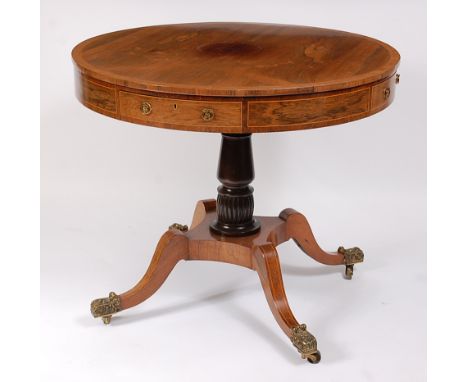 A Regency faded rosewood pedestal drum / rent table, the crossbanded top with boxwood stringing above a frieze having four dr