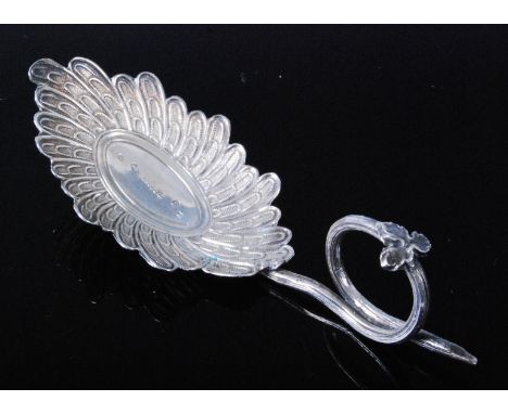 A George III silver caddy spoon, having an oval radial flower head bowl with tendril handle surmounted by a leaf, maker Warde