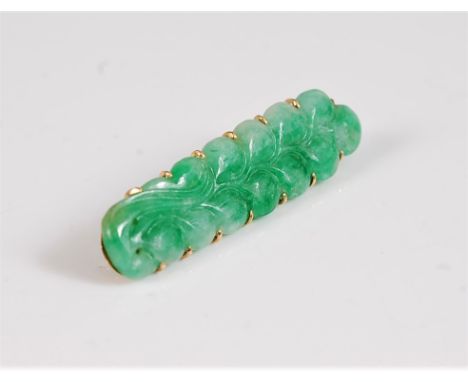A jade brooch, the jade carved as a sprig of closed flower buds, claw mounted with a framework to reverse holding the horizon