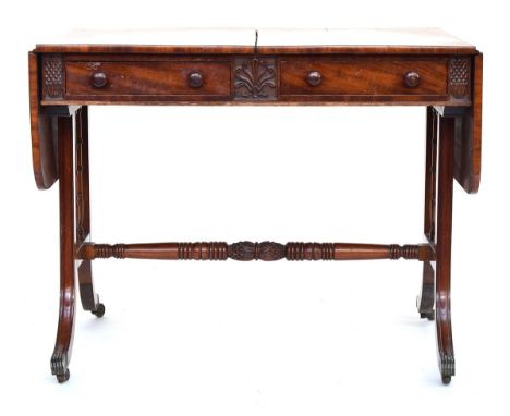 A 19th century mahogany sofa table, having two frieze drawers and two blind frieze drawers, the swept legs joined by lotus ca