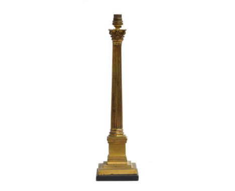 A gilt metal table lamp in the form of a fluted corinthian column, on square base upon an ebonised plinth, 45cm high 