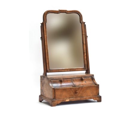 An early 19th century dressing mirror, shaped plate with bevelled glass, over two cavetto drawers and one long drawer, on bra