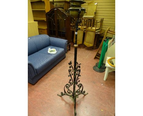 Vintage oil lamp on black metal stand with scrollwork and floral leaf decoration