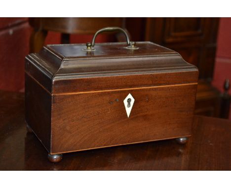 An early 19th century rectangular mahogany tea caddy, brass swing handle, ivory kite shaped escutcheon, bun feet, 23cm wide