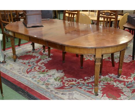 An Edwardian mahogany D-end wind out dining table, reeded edge, cockbeaded frieze, tapering square reeded supports with acant