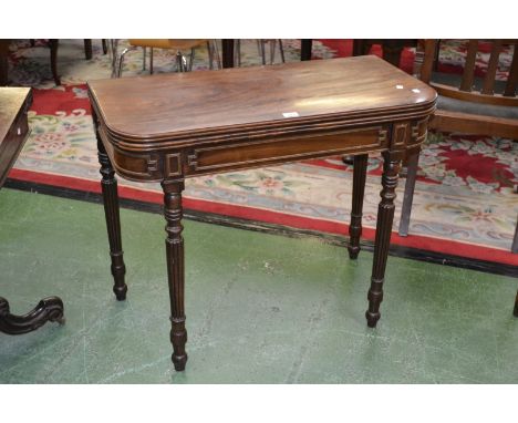 A George III card table, reeded edge to top, fabric playing area, cockbeaded frieze, turned and reeded supports.