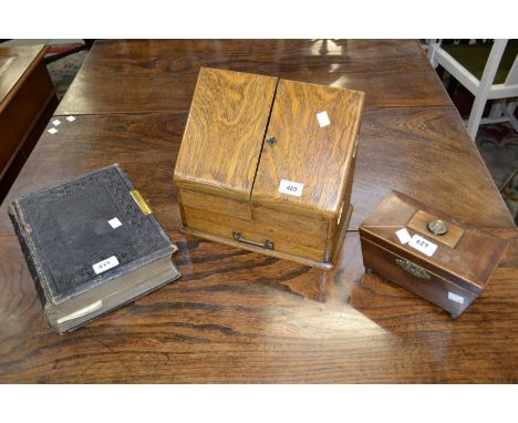 An Edwardian light oak slope front stationery cabinet, hinged doors, fitted with an arrangement of dividers, ink pot and cove