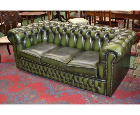 A deep button back green leather three seat Chesterfield sofa