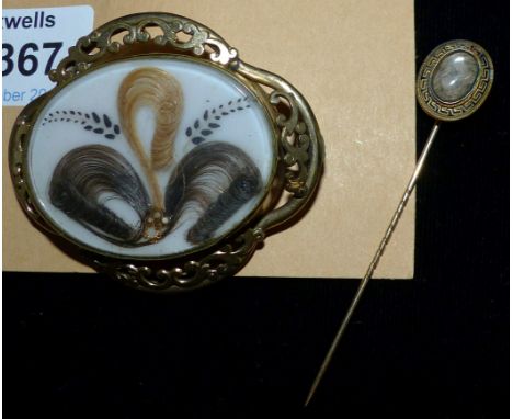 A Victorian gilt metal brooch set with jewelled scrolled hair; a mourning stick pin set with plaited hair