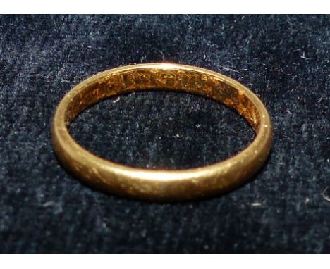 A 22 carat hallmarked gold wedding ring, marks worn, tests as 22 carat, 4 gm