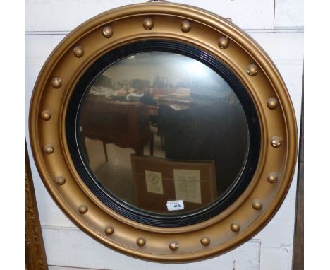 A circular convex wall mirror in gilt ball frame