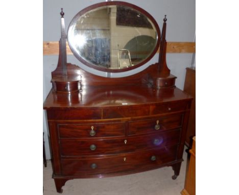 An inlaid mahogany bow front dressing table with oval mirror, 2 long, 2 short and 2 jewellery drawers