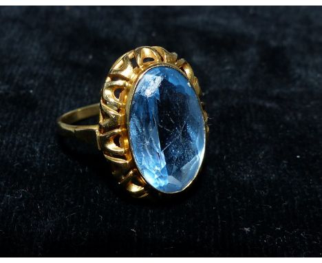 A dress ring set pale blue stone in yellow metal shank (tests 18ct)