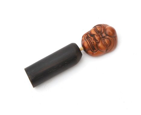  A wood mask netsuke shaped as a noh-mask. Carved and mounted on a base. Japan, Taishō period (1912-1926). Hoogte ca. 6,5 cm.
