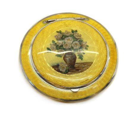 An enamelled silver compact,1930s, likely Austrian, of disc form, throughout with yellow guilloche enamel over a variety of e