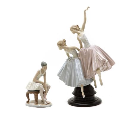 A Lladro porcelain figure group,of two ballerinas, on a wood socle, printed marks,49cm hightogether with a Nao porcelain figu