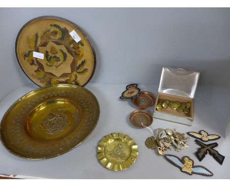A collection of militaria, cap badges, plates, ash trays, etc. 