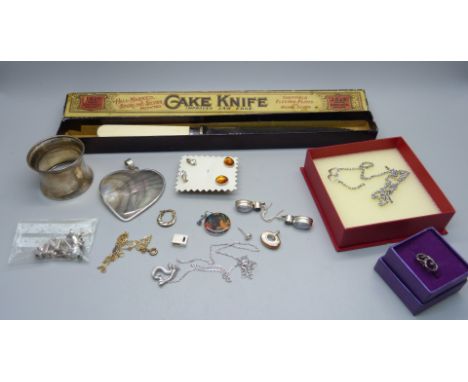 A silver napkin ring, silver jewellery and a cake knife with silver ferrule 