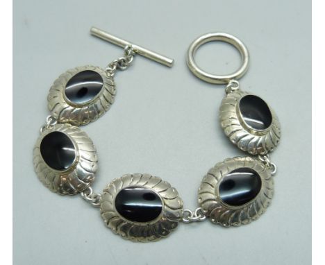 A silver bracelet with T-bar fastener and black stones 