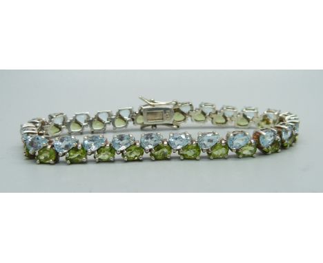 A silver, topaz and peridot bracelet 
