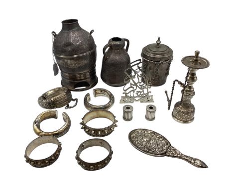 A collection of Middle Eastern silver and white metal items to include ornamental water jugs, bangle bracelets, shisha pipe f