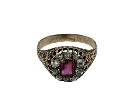 An unmarked yellow metal 18th century ruby and diamond dress ring. Central cushion cut ruby of good colour(wear to facets and