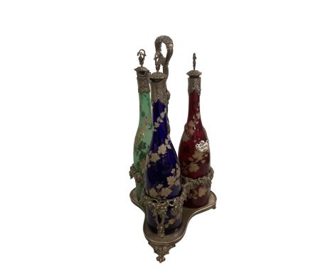 Late C19th Bohemian three bottle decanter set with silver plated grape and vine cast decoration to stand and unmarked white m