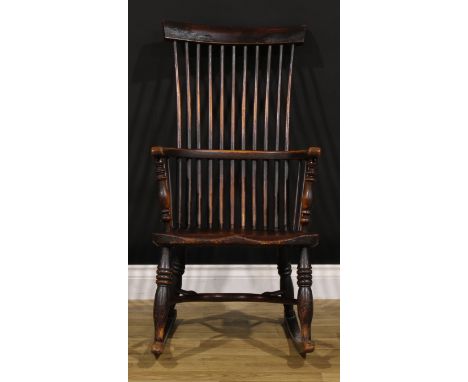A 19th century beech, ash and elm comb-back Windsor rocking chair, possibly Scottish, one-piece mid-rail, turned arm posts, s