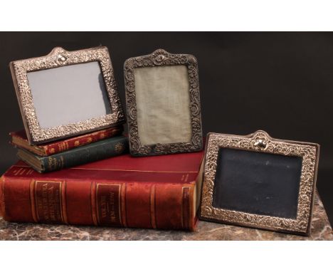 A pair of Victorian style silver rectangular easel photograph frames, embossed with flowers and scrolling leaves, 17.5cm wide