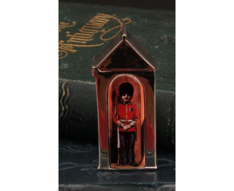 A silver and enamel novelty vesta case, decorated with a guardsman in a sentry box, 6cm long, marked sterling