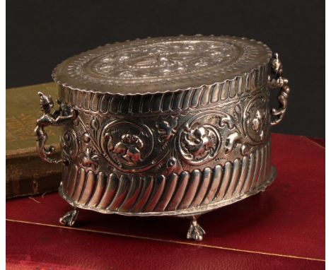 A Victorian silver oval tea caddy, chased in the 17th century taste with flowering scrolling leafy stems, winged term handles