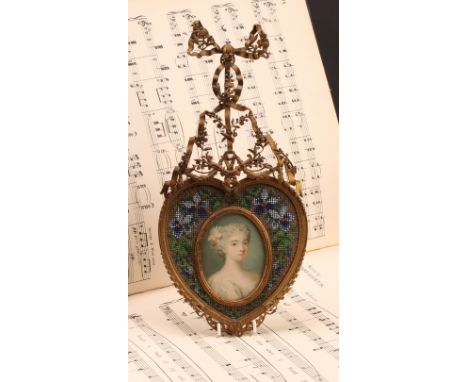 A 19th century French gilt metal and beadwork picture frame, the heart shaped frame centred by an oval lithograph, of a young