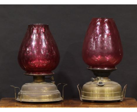 An early 20th century heater lamp, The Union Burner, by Wright &amp; Butler, Birmingham, cranberry glass shade, 42cm high; an