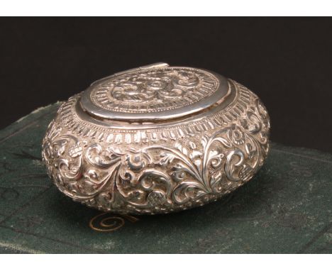 A 19th century Indian silver oval snuff box, chased overall with flowers and foliage, lotus base, hinged cover, 7.5cm wide, s