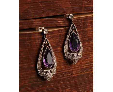 A pair of unmarked white metal art nouveau style diamond and amethyst chandelier drop earrings, the central pear cut light pu
